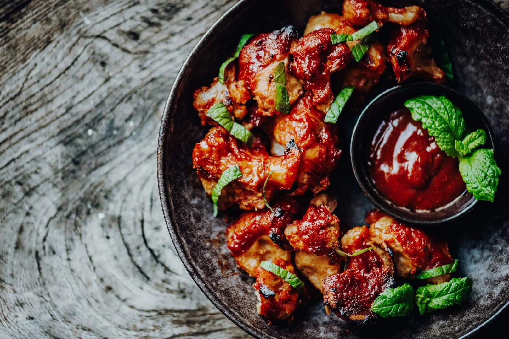 Barbecue chicken bites with dipping sauce and mint