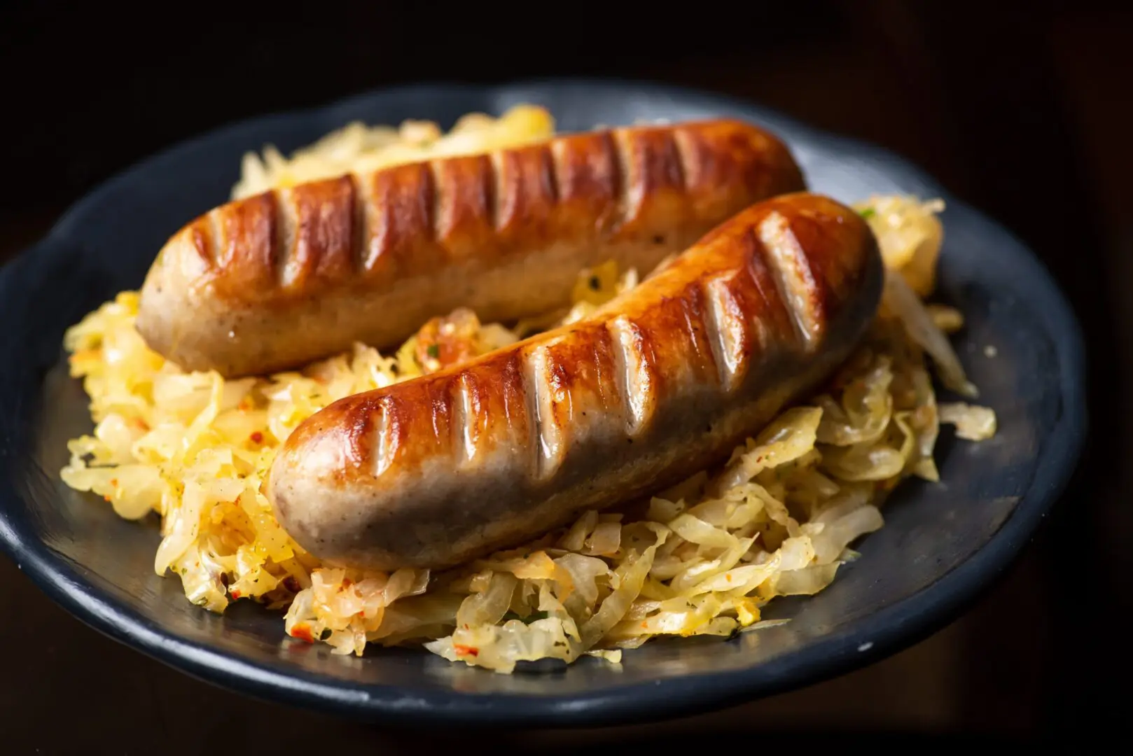 Two grilled sausages on sauerkraut