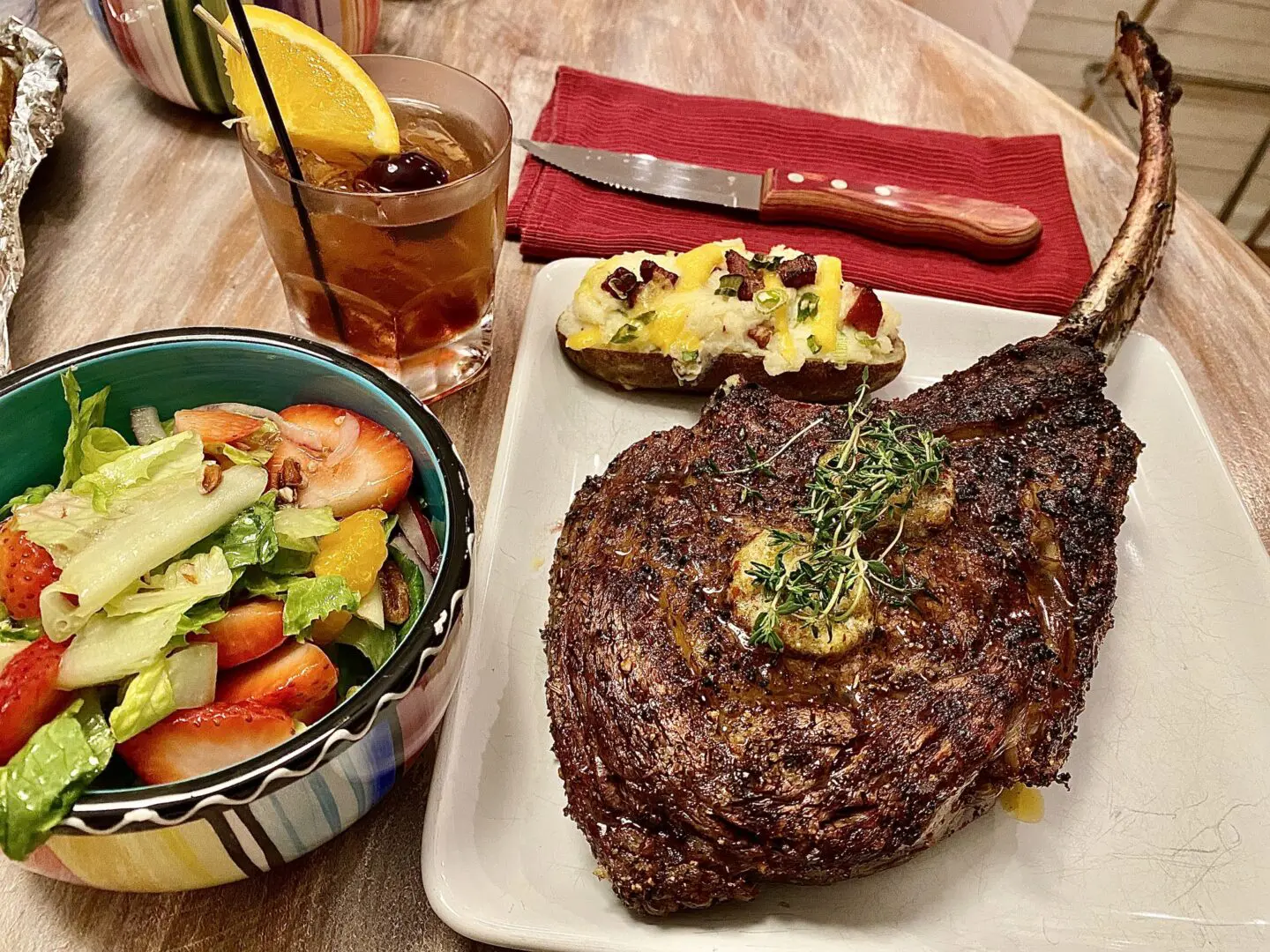 Tomahawk steak with salad and loaded potato