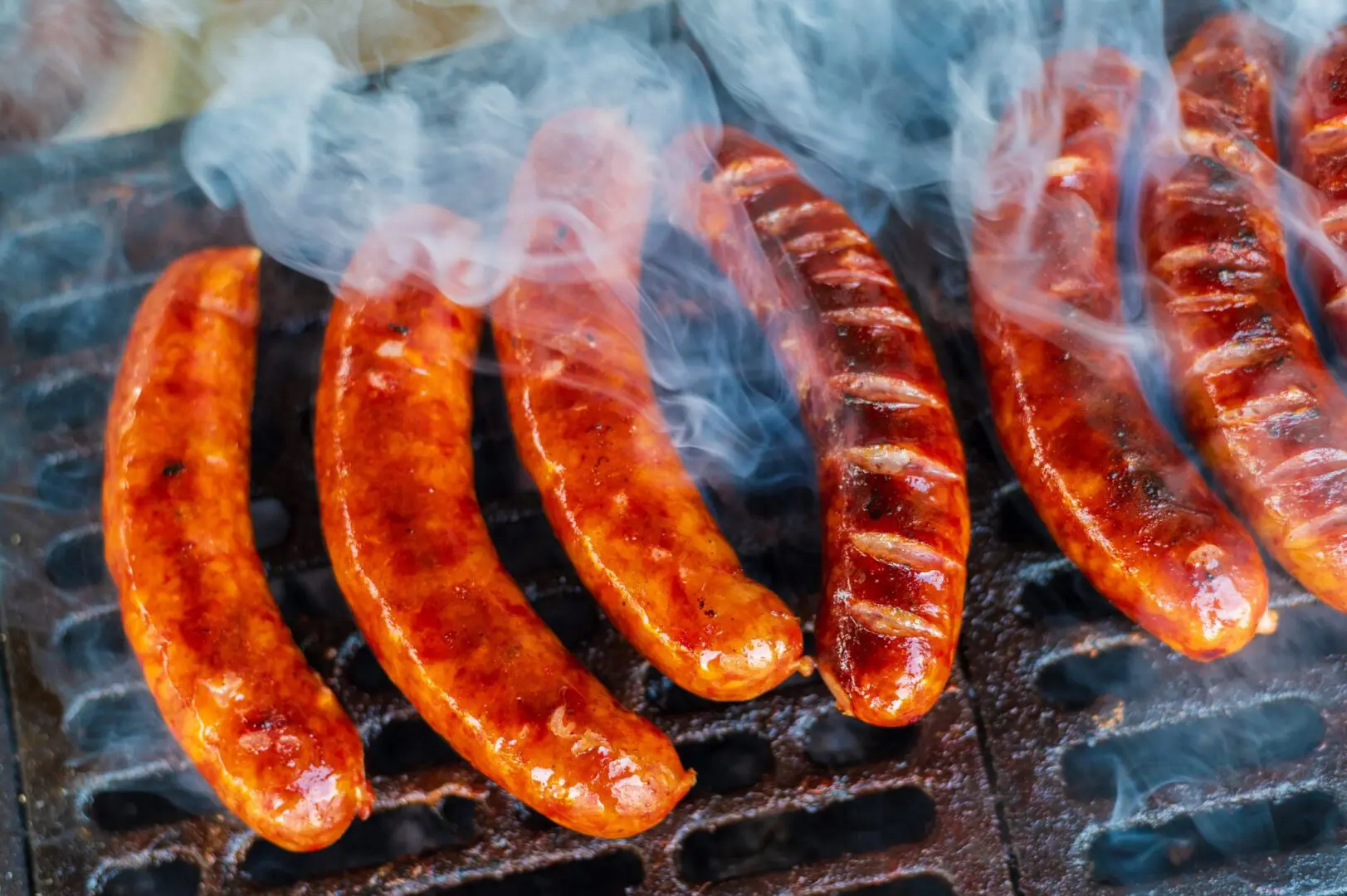 Smoky grilled sausages sizzling on barbecue