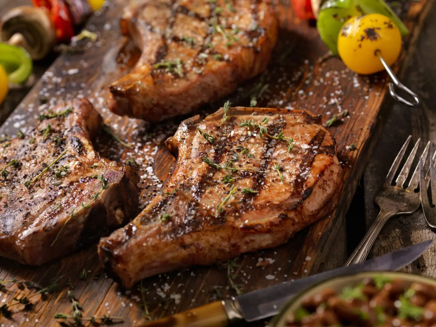 Grilled pork chops with herbs and skewers