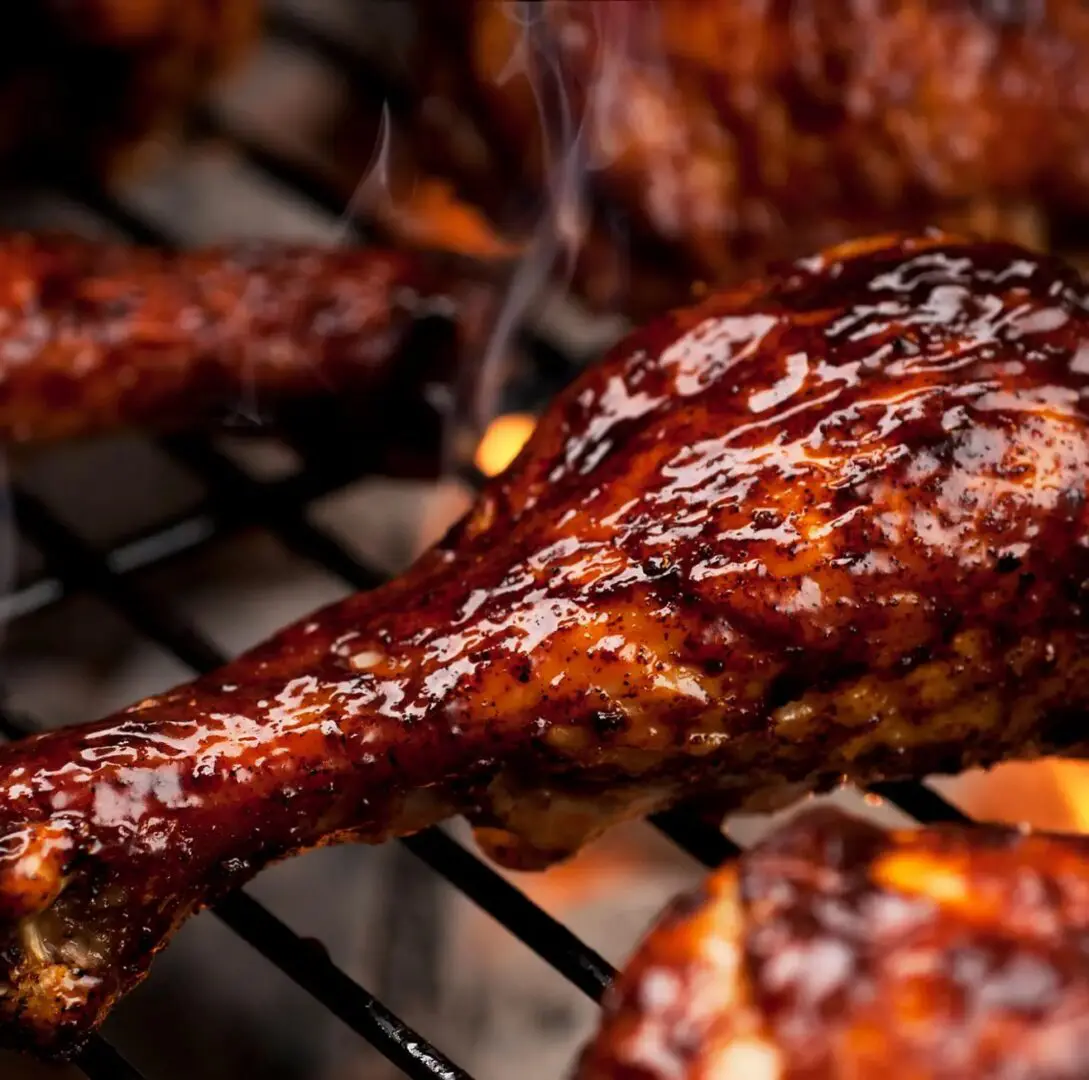 Barbecued chicken cooking over open flame