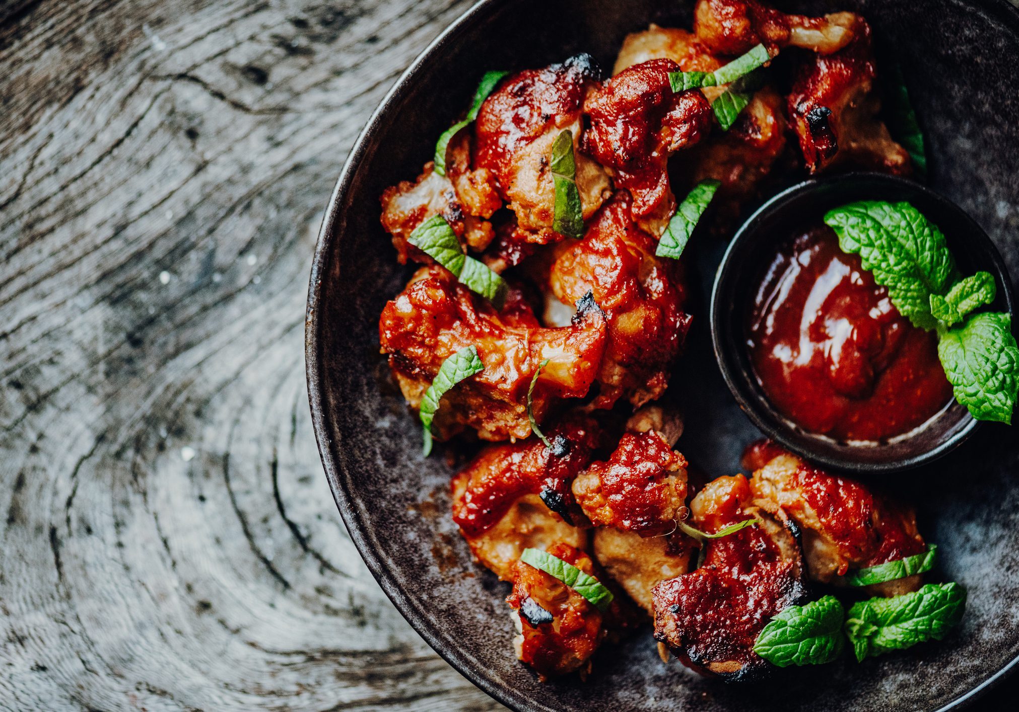 Barbecue chicken bites with dipping sauce and mint
