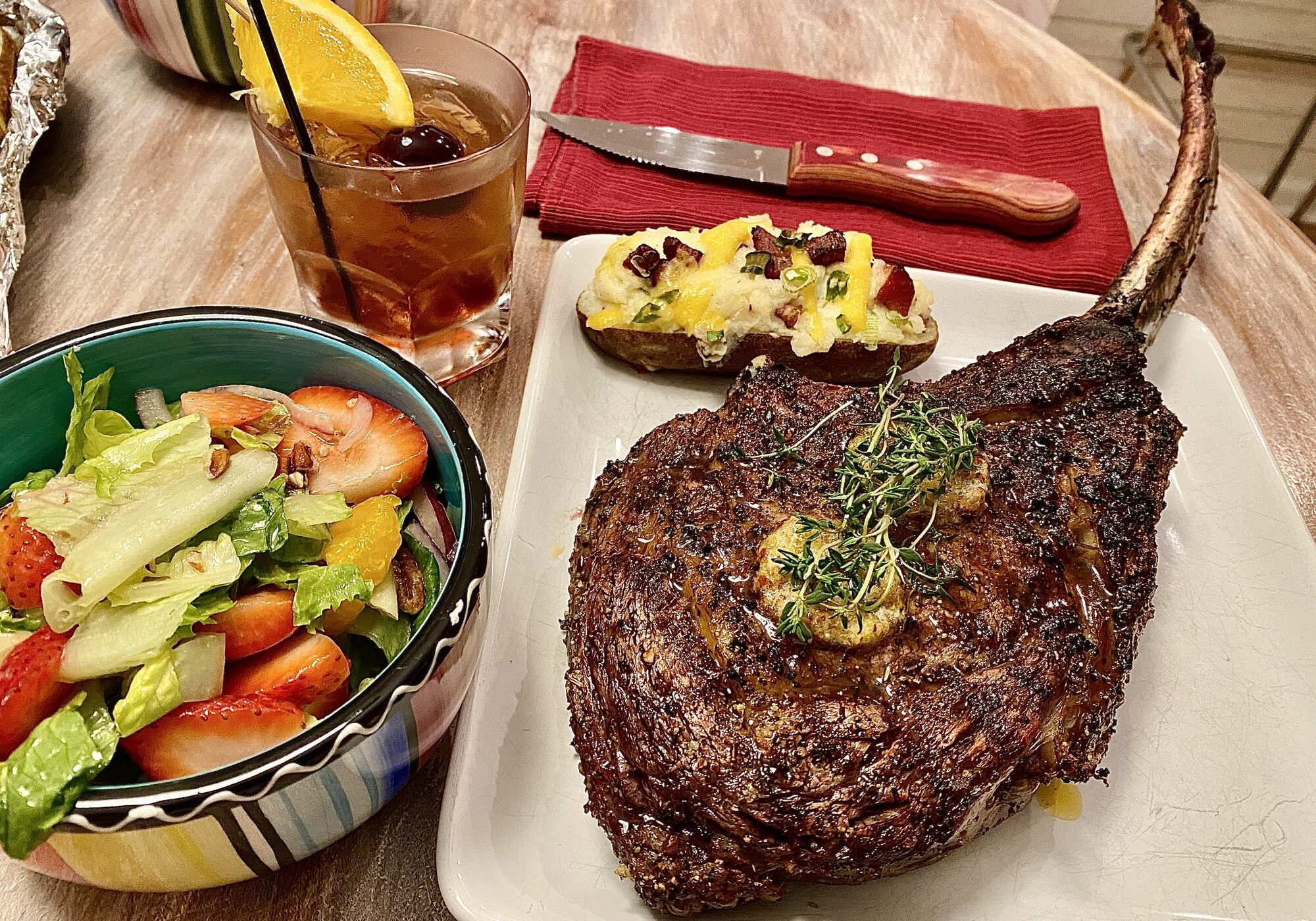 Tomahawk steak with salad and loaded potato