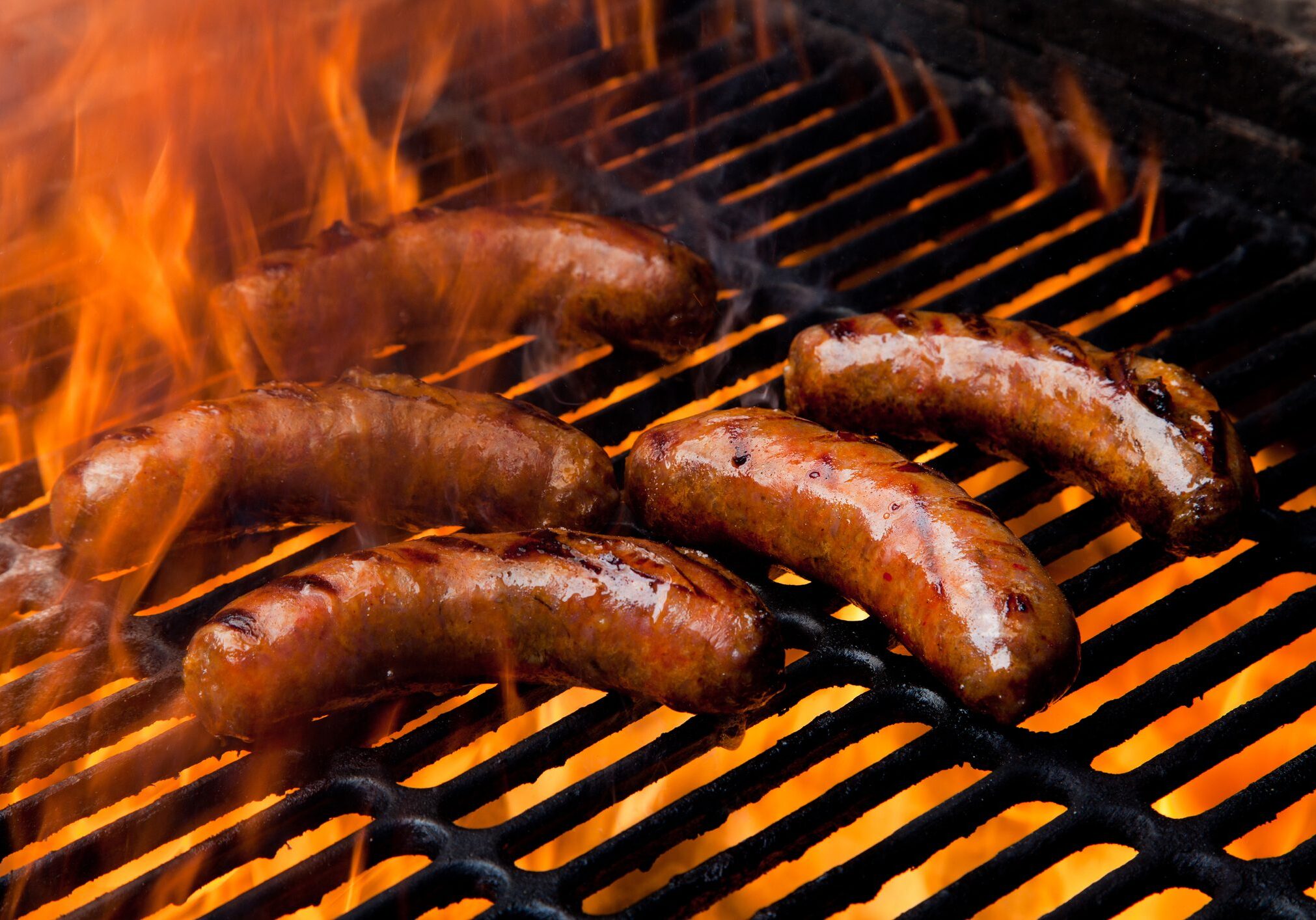 Sausages grilling over open flame