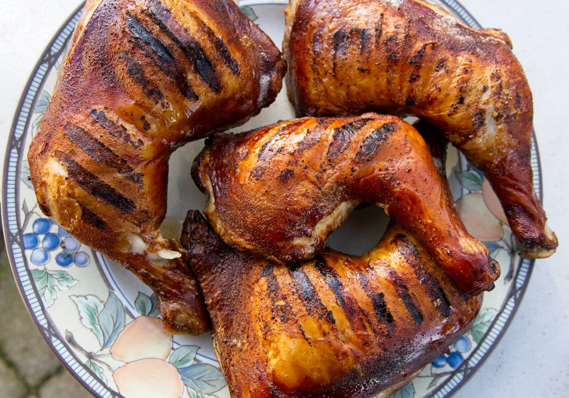Grilled chicken quarters with charred grill marks