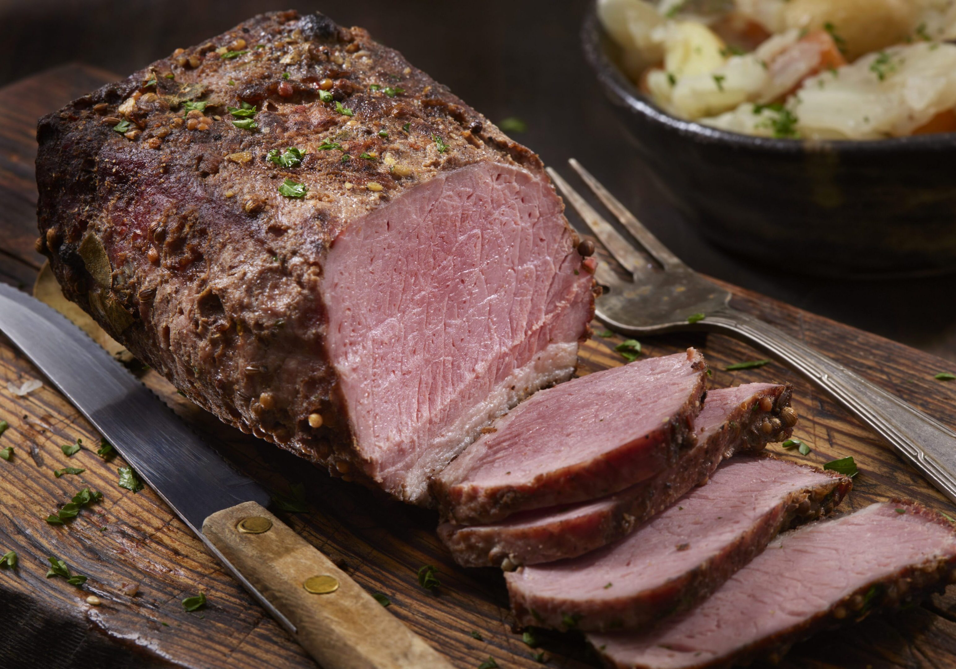 Sliced roast beef on wooden cutting board
